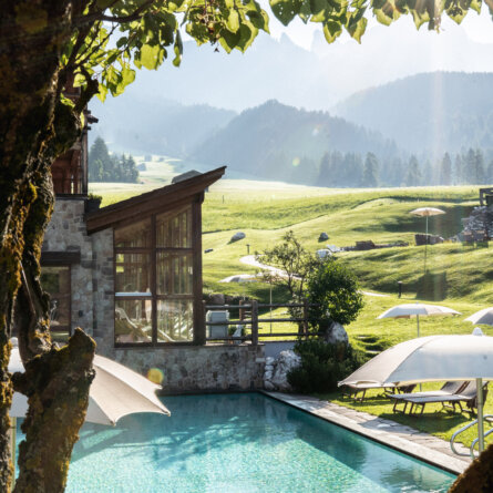 Blick ueber den Pool des Cyprianerhof Dolomit Resort Richtung Rosengarten I upscale