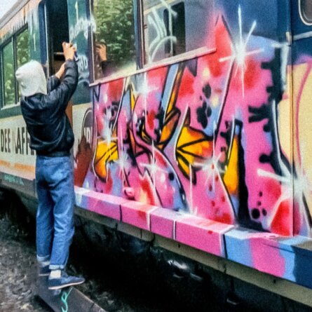 wysiwyg_Presse_Ausstellungen_ESWB_Cisco_sprueht_1987_ein_Window-Down-Panel_an_einer_S-Bahn_im_Yard_Bergedorf_Foto_Michael_Timm_EINE_STADT_WIRD_BUNT(1)