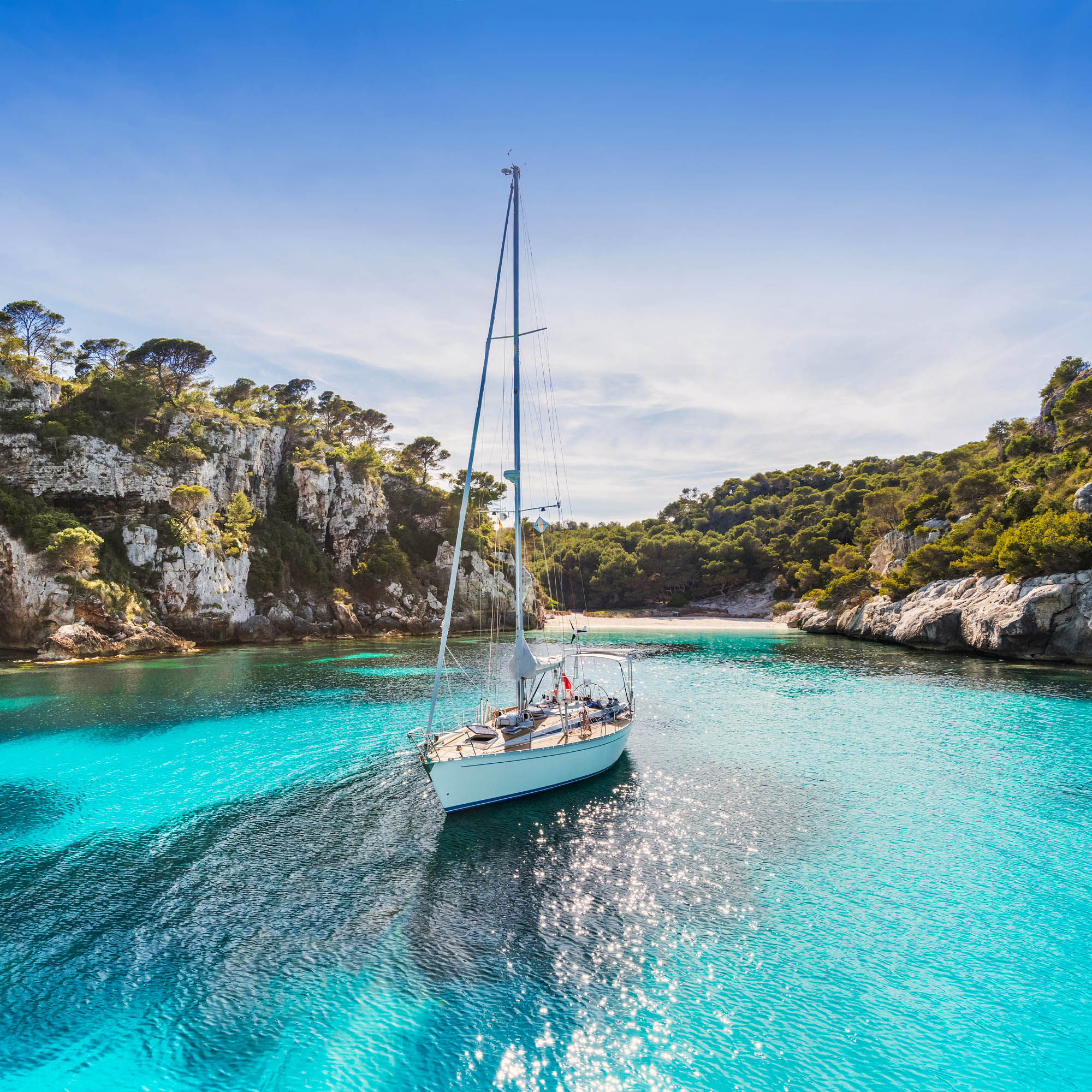 Beautiful beach with sailing boat yacht, Cala Macarelleta, Menor