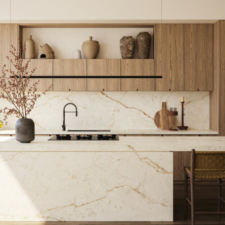 Minimalist kitchen with marble countertops, wooden cabinets, black faucet, decorative vases, and patterned rug.