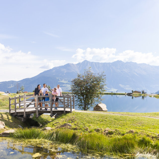 Österreich I Familie-am-Speicherteich-Wolfsee-in-Serfaus-Fiss-Ladis_Serfaus-Fiss-Ladis-Marketing-GmbH_Daniel-Zangerl-eye5-